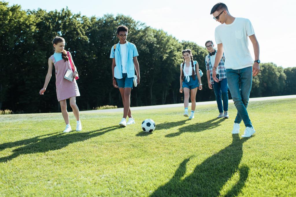 futbol topu parkta oynarken genç çok ırklı arkadaşlar  - Fotoğraf, Görsel