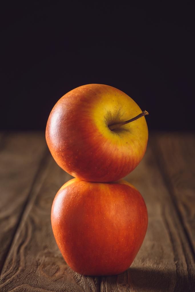 primer plano de manzanas rojas apiladas en mesa de madera rústica en negro
 - Foto, Imagen