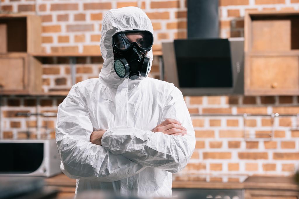tuholaistorjuntatyöntekijä seisoo univormussa ristissä kädet keittiössä
 - Valokuva, kuva