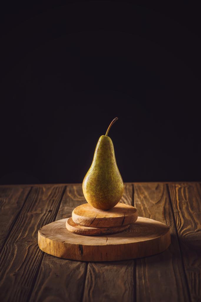 gros plan de poire mûre sur des planches empilées et sur une table rustique en bois noir
 - Photo, image