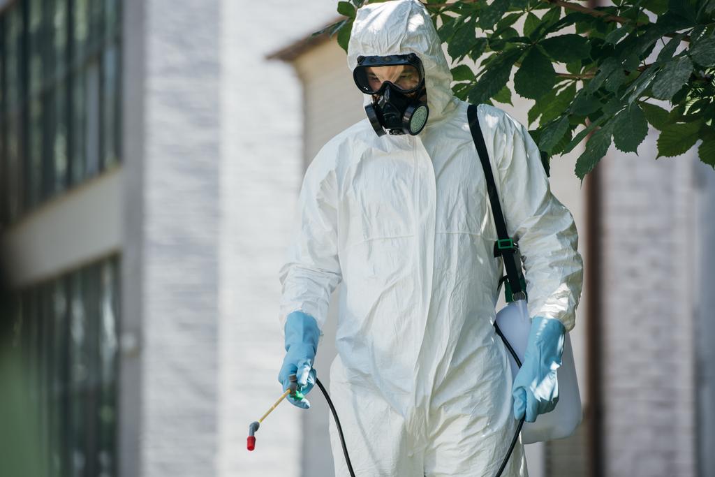 Schädlingsbekämpfer sprühen Pestizide mit Sprüher auf Straße   - Foto, Bild