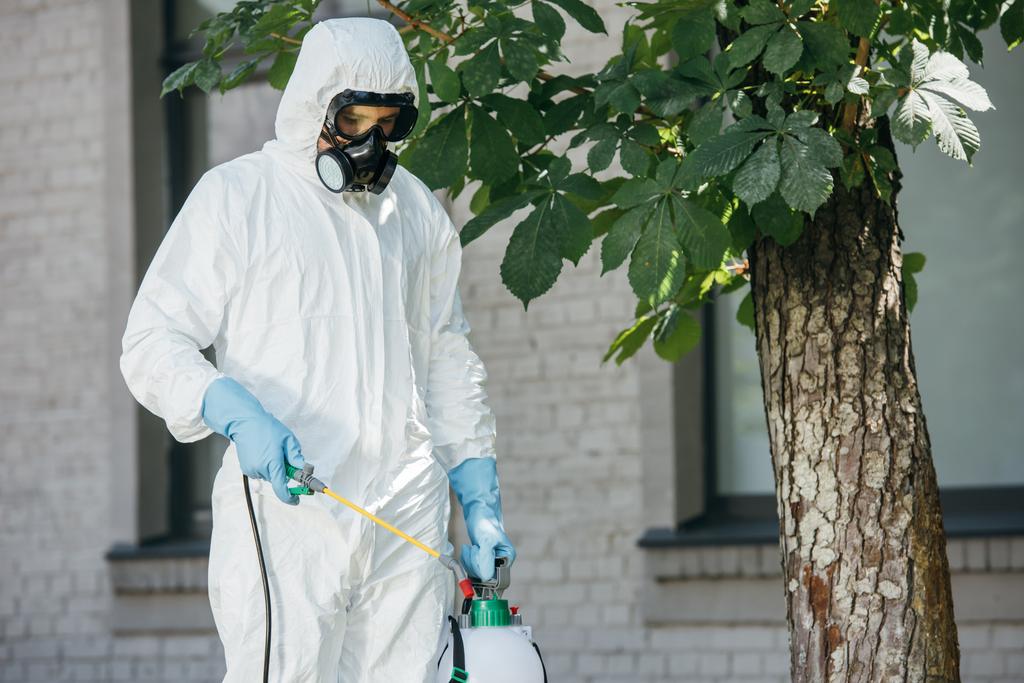працівник боротьби з шкідниками розпилює пестициди на вулиці
 - Фото, зображення