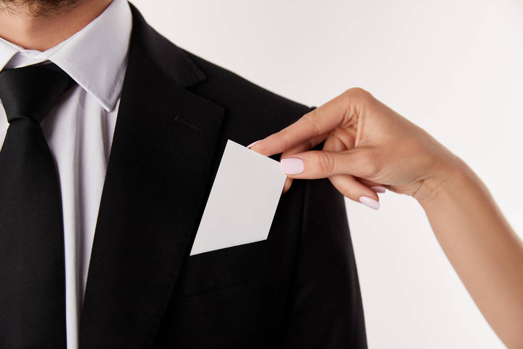 immagine ritagliata di donna d'affari mettendo biglietto da visita vuoto in tasca di uomo d'affari isolato su sfondo bianco
  - Foto, immagini