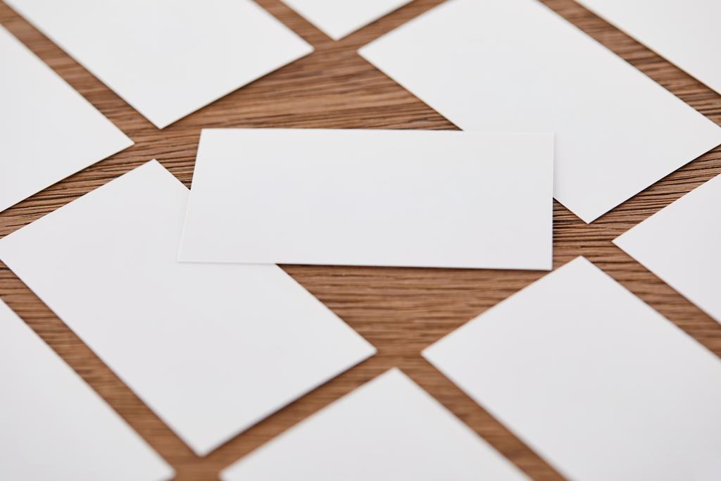 Крупный план набора пустых визиток за деревянным столом
  - Фото, изображение