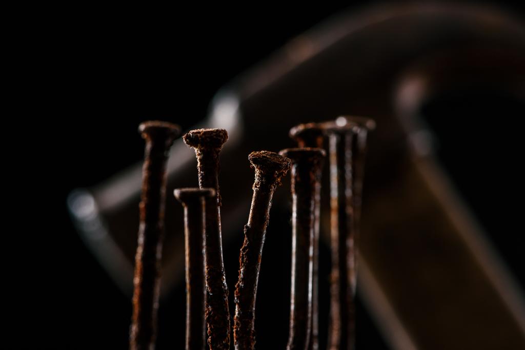  επιλεκτική εστίαση ρετρό σκουριασμένα καρφιά και σφυρί που απομονώνονται σε μαύρο - Φωτογραφία, εικόνα