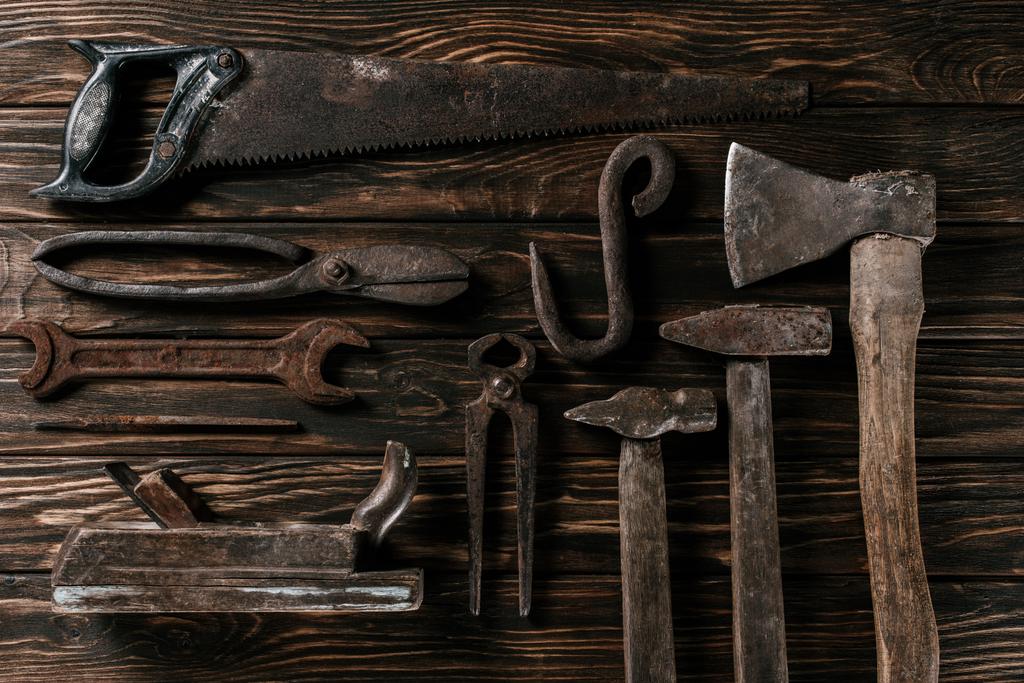 плоский укладка с ассортиментом старинных ржавых столярных инструментов на деревянной поверхности
 - Фото, изображение