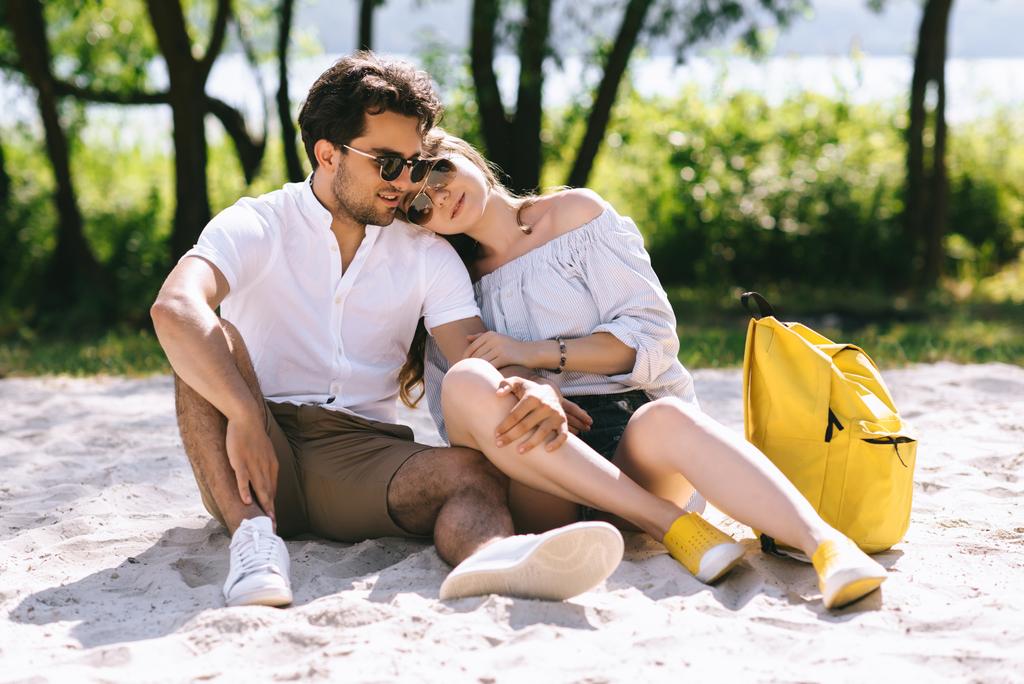 Affectionate para przytulanie i siedzi na głównej plaży miejskiej - Zdjęcie, obraz
