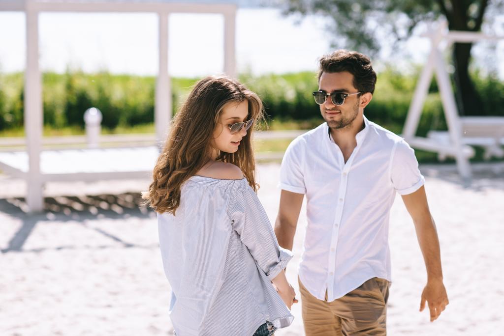 pár v sluneční brýle a ležérní oblečení na písečné městské pláže - Fotografie, Obrázek