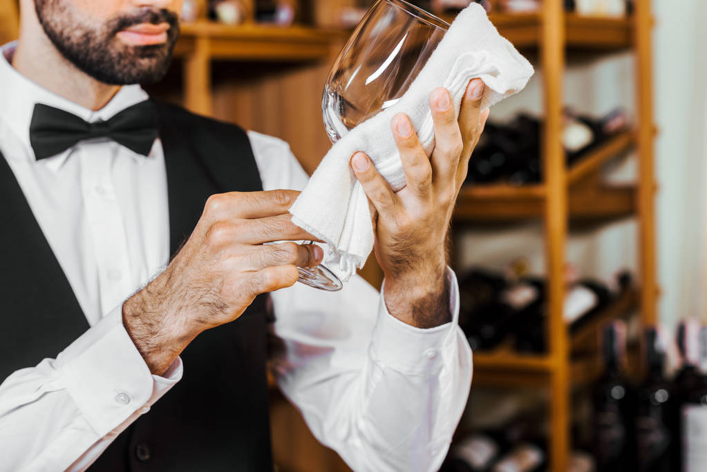 обрізаний знімок молодого виноробу, що протирає скло у винному магазині
 - Фото, зображення