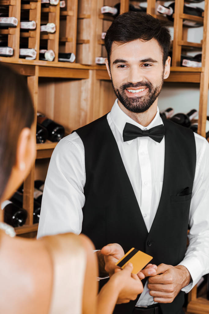 steward wina przy złotej karty kredytowej z kobieta klienta w sklepie wina - Zdjęcie, obraz