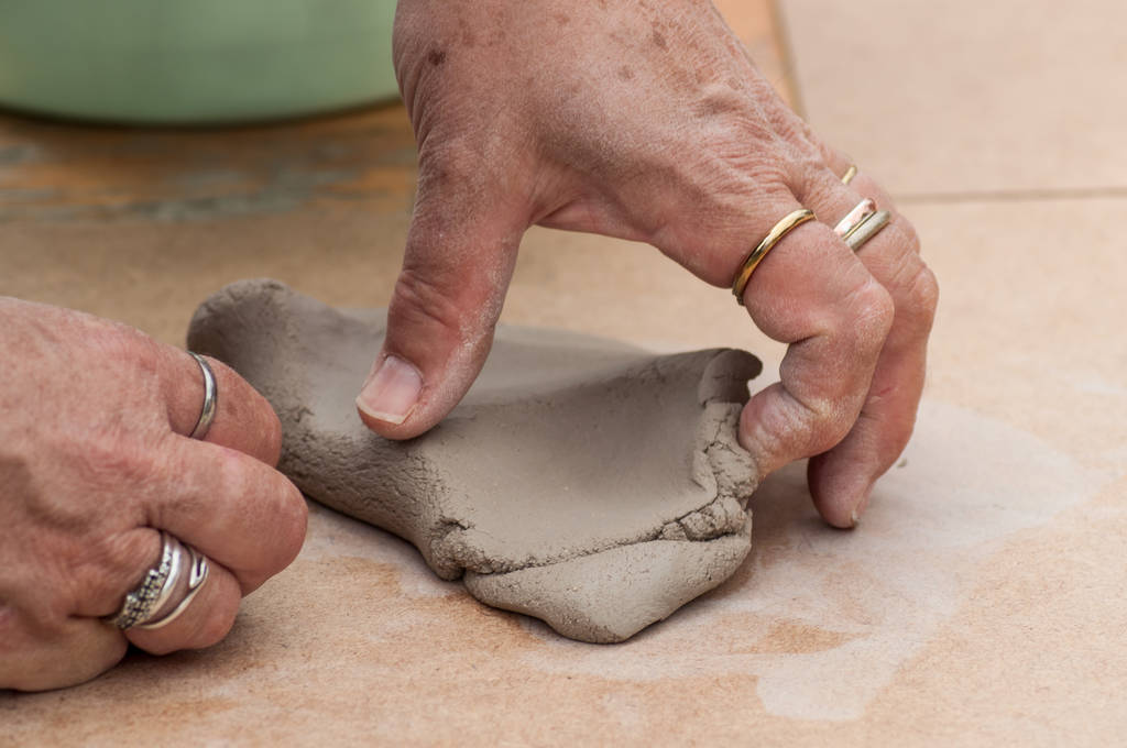 closeup of hands of old woman making clay pottery bowl in outdoor  - Photo, Image