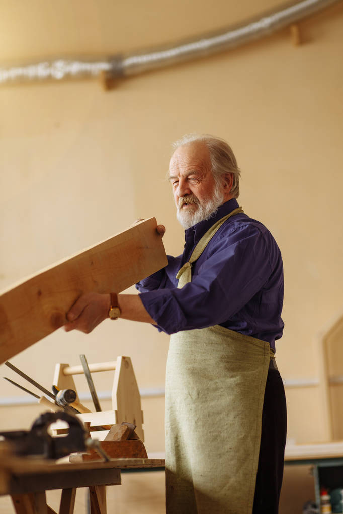 old craftsman defining the length of the board while working - Photo, Image