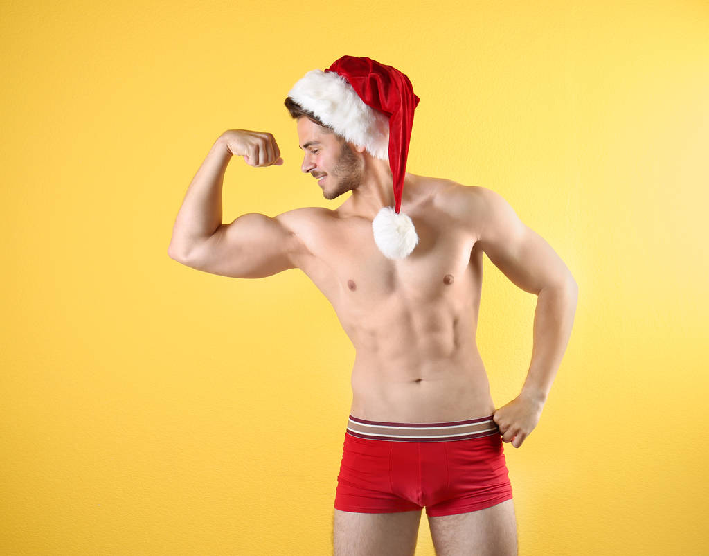 Shirtless νέος Άγιος Βασίλης με σέξι σώμα σε χρώμα φόντου - Φωτογραφία, εικόνα