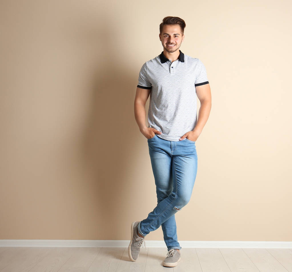 Mladý muž v stylové džíny světle zdi - Fotografie, Obrázek
