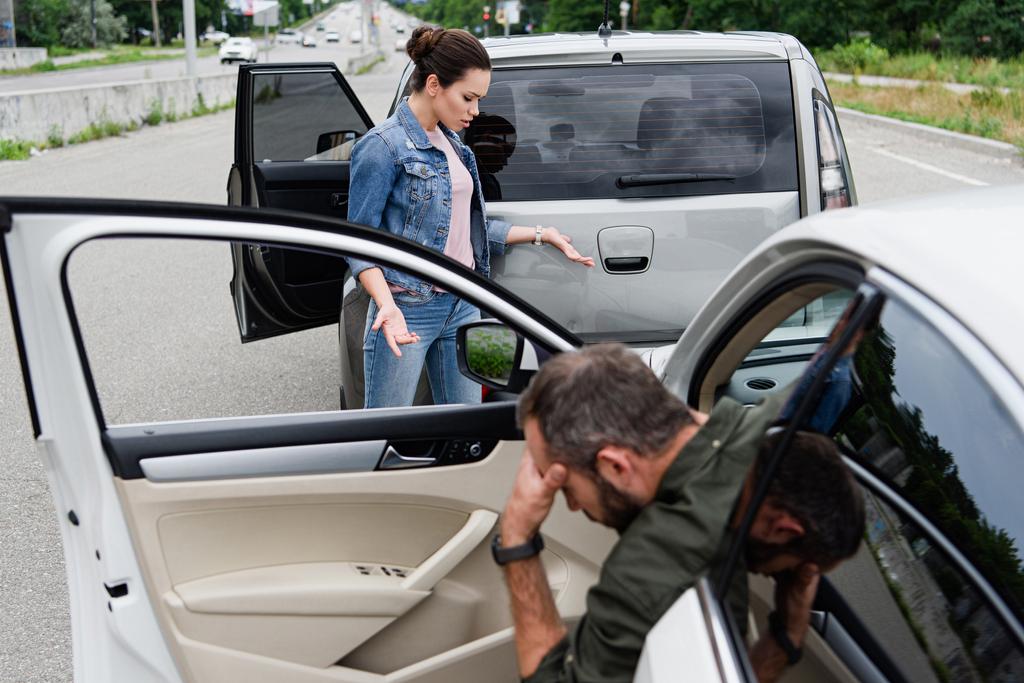 naiskuljettaja katselee autoja auto-onnettomuuden jälkeen tiellä
 - Valokuva, kuva