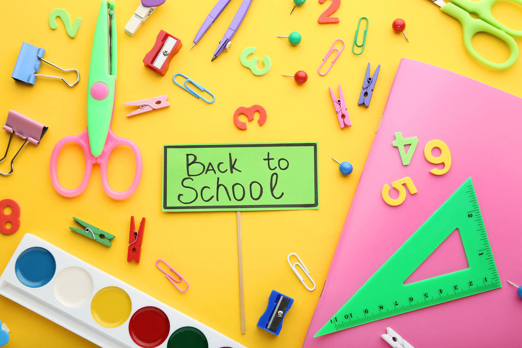 Inscriptions Back To School with school supplies on yellow background - Photo, Image