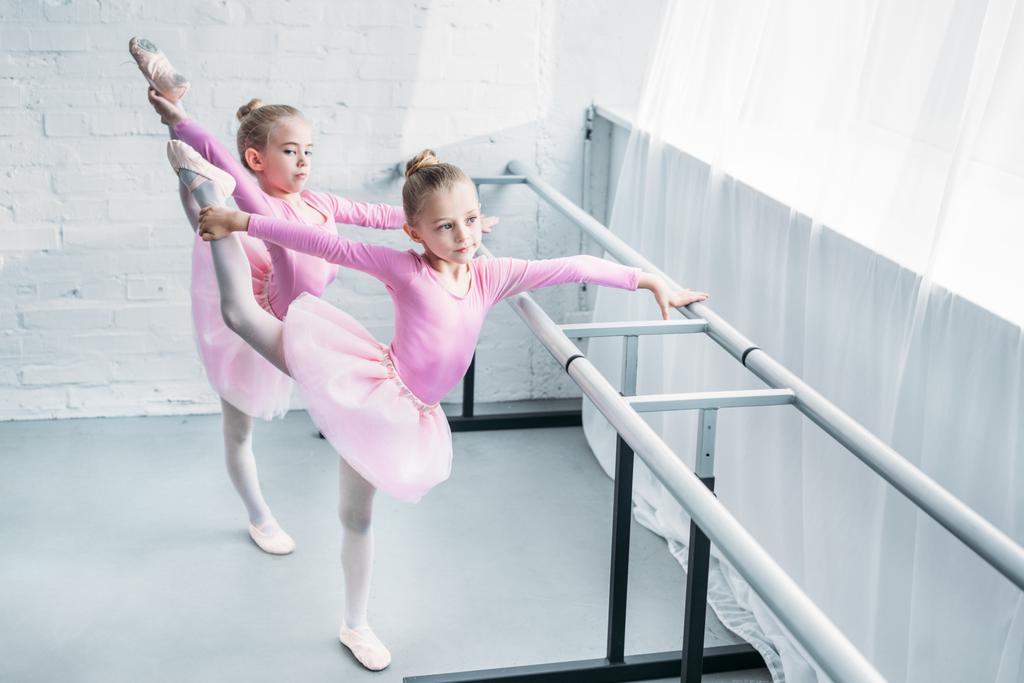 high angle view of cute little ballet dancers stretching in ballet school - Photo, Image