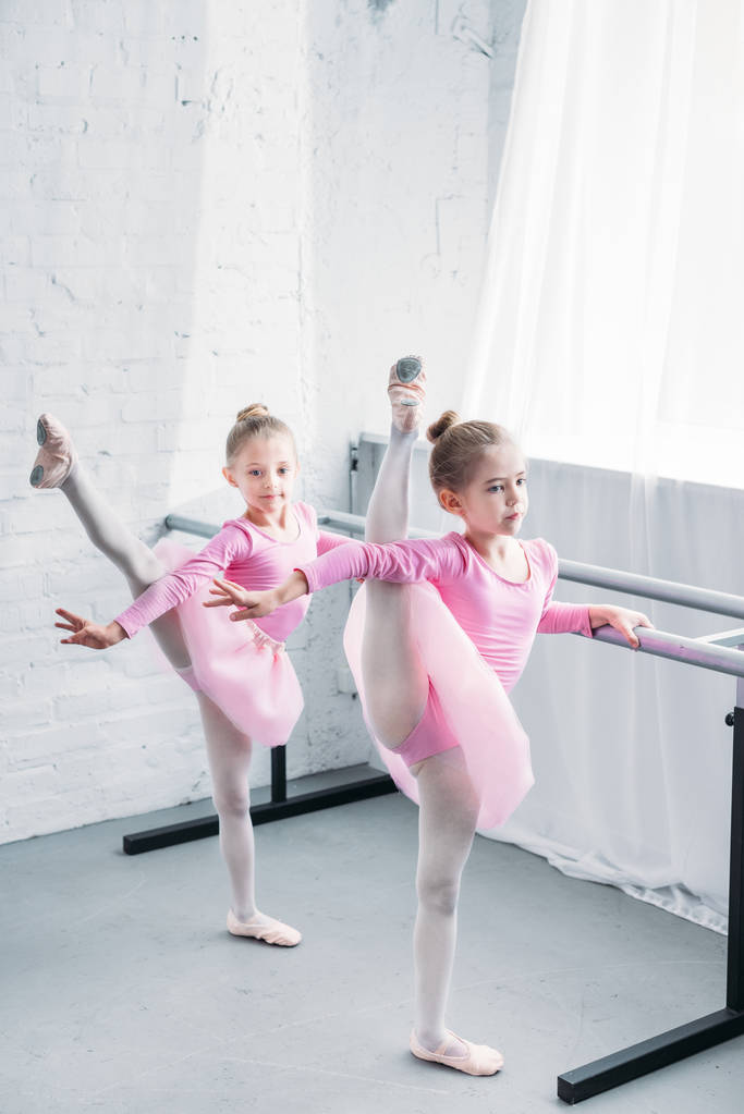 χαριτωμένα παιδάκια στα ροζ Τουτού φούστες τέντωμα και χορού στη Σχολή Μπαλέτου - Φωτογραφία, εικόνα