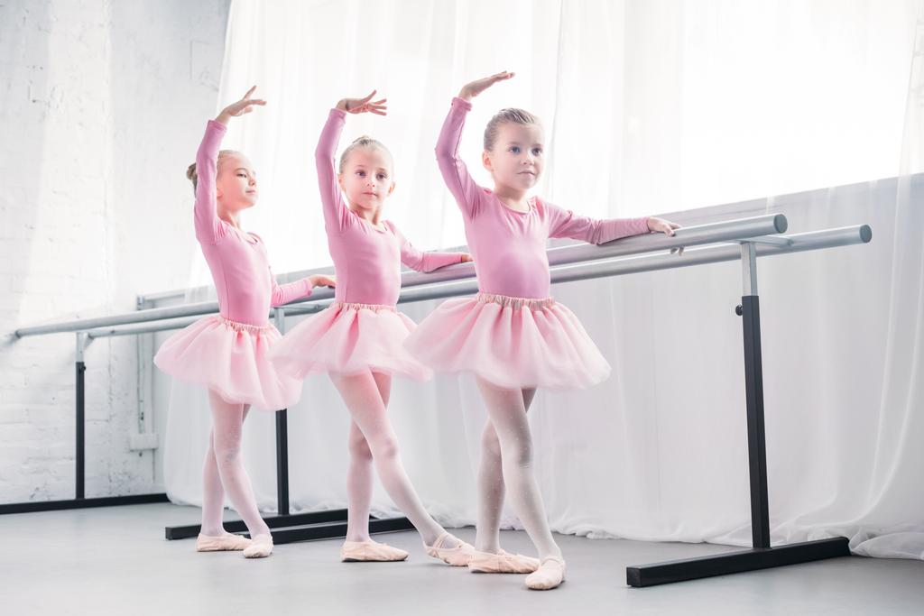 повнометражний вид на чарівних маленьких дітей в рожевих спідницях, які танцюють в балетній студії
  - Фото, зображення