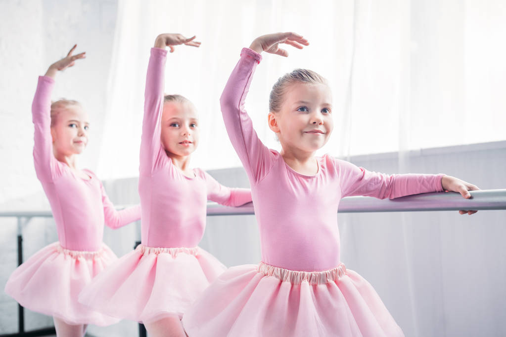 バレエ スタジオで踊るピンクのチュチュ スカートのかわいい笑顔の子供たち  - 写真・画像