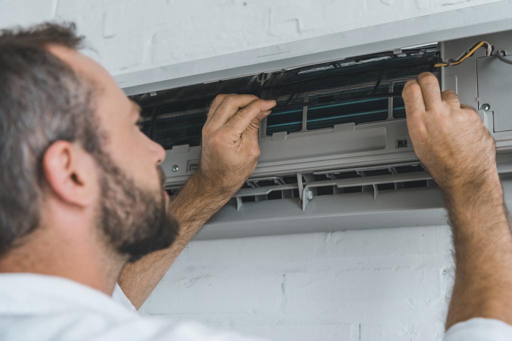 male bearded worker repairing air conditioner - Photo, Image
