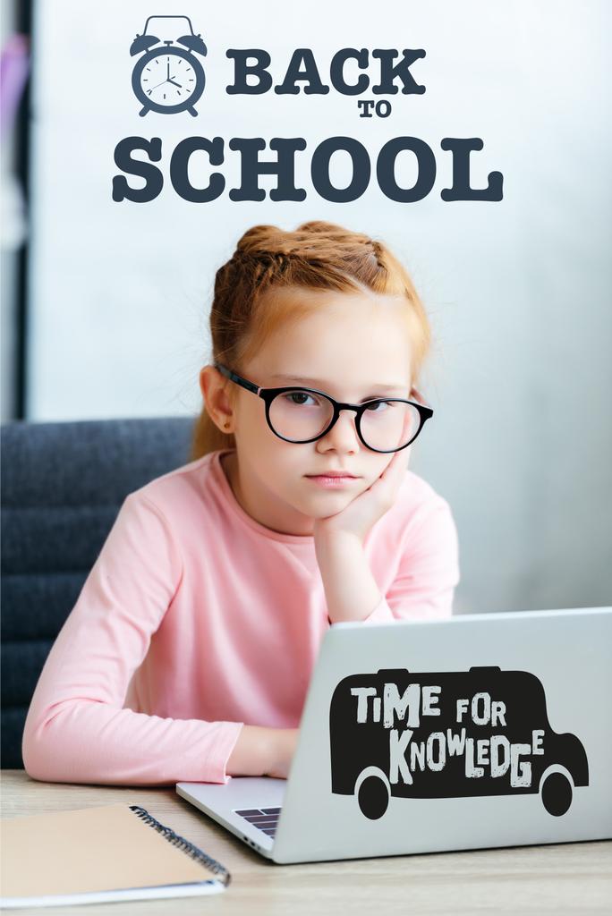 gelangweiltes kleines Schulkind mit Brille, das mit Laptop in die Kamera blickt, "zurück in die Schule" und "Zeit für Wissen" lernt - Foto, Bild
