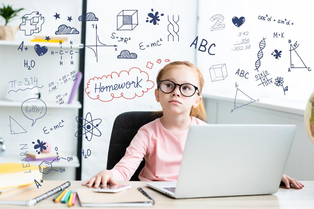 Nachdenkliches kleines Schulkind mit Brille, das am Schreibtisch sitzt und Laptop mit Lernsymbolen benutzt - Foto, Bild