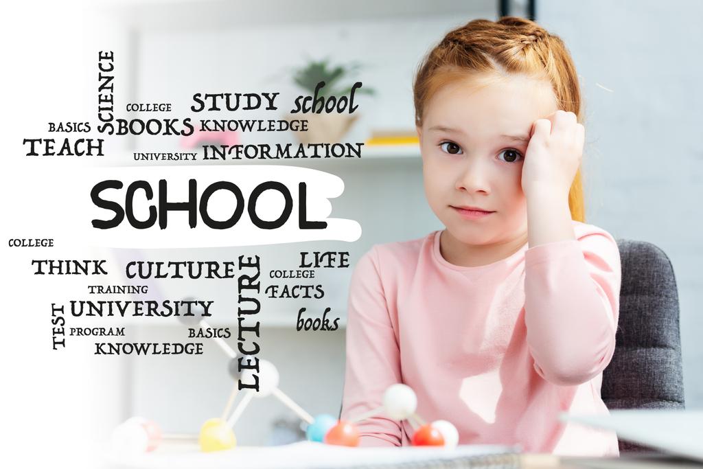 mooie rode haired schoolmeisje camera kijken tijdens zijn studies met moleculair model thuis, met school word - Foto, afbeelding