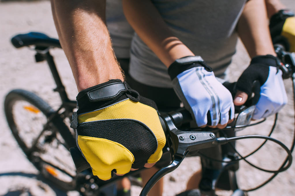 Mãos de um em luvas de esportes segurando o volante da bicicleta. Close-up
. - Foto, Imagem