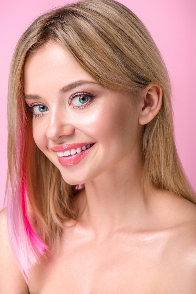 крупным планом портрет улыбающейся молодой женщины с красочными прядями волос, смотрящей в камеру, изолированную на розовом
 - Фото, изображение