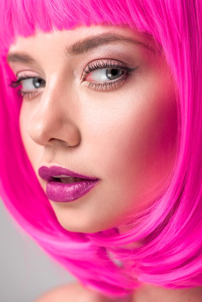 attraktive junge Frau mit pinkfarbenem Bob-Schnitt blickt in die Kamera - Foto, Bild