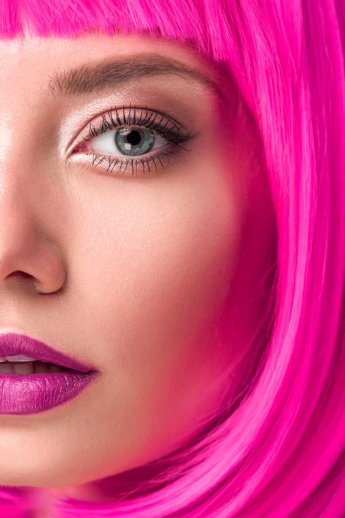 частичный вид привлекательной молодой женщины с розовыми волосами, смотрящей в камеру
 - Фото, изображение