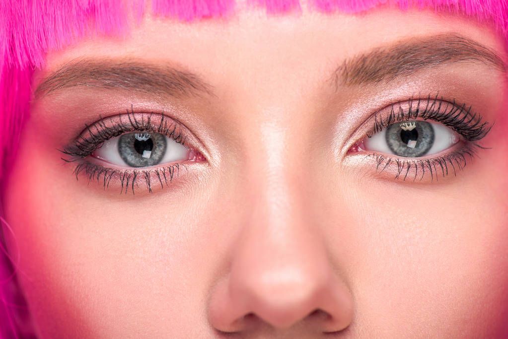 частичный вид красивой молодой женщины с розовыми волосами, смотрящей в камеру
 - Фото, изображение