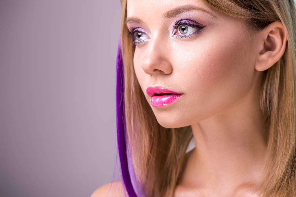 Close-up portret van mooie jonge vrouw met kleurrijke strengen in haar weg op zoek - Foto, afbeelding