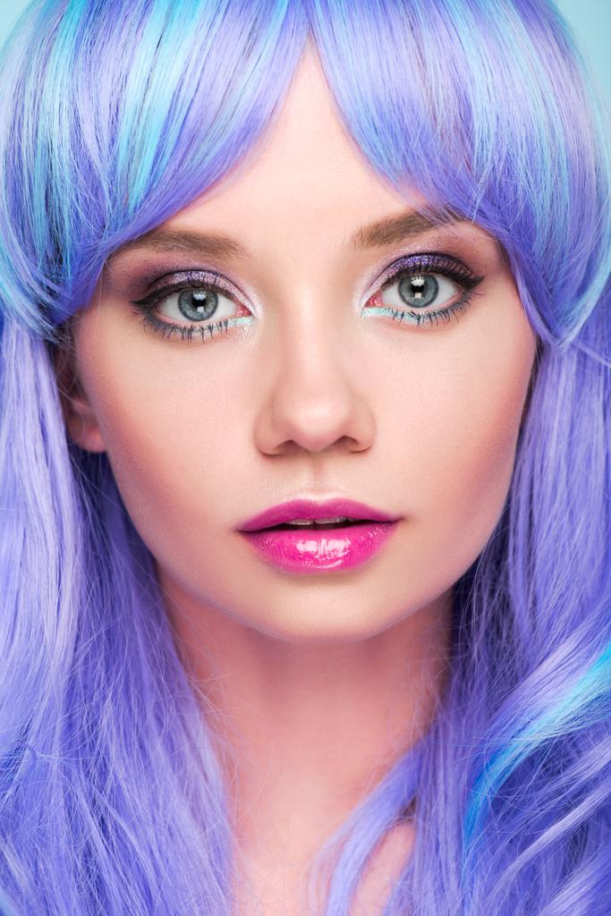 Close-up πορτρέτο της αισθησιακή νεαρή γυναίκα με μπλε μαλλιά βλέπουν φωτογραφική μηχανή που απομονώνονται σε μπλε - Φωτογραφία, εικόνα