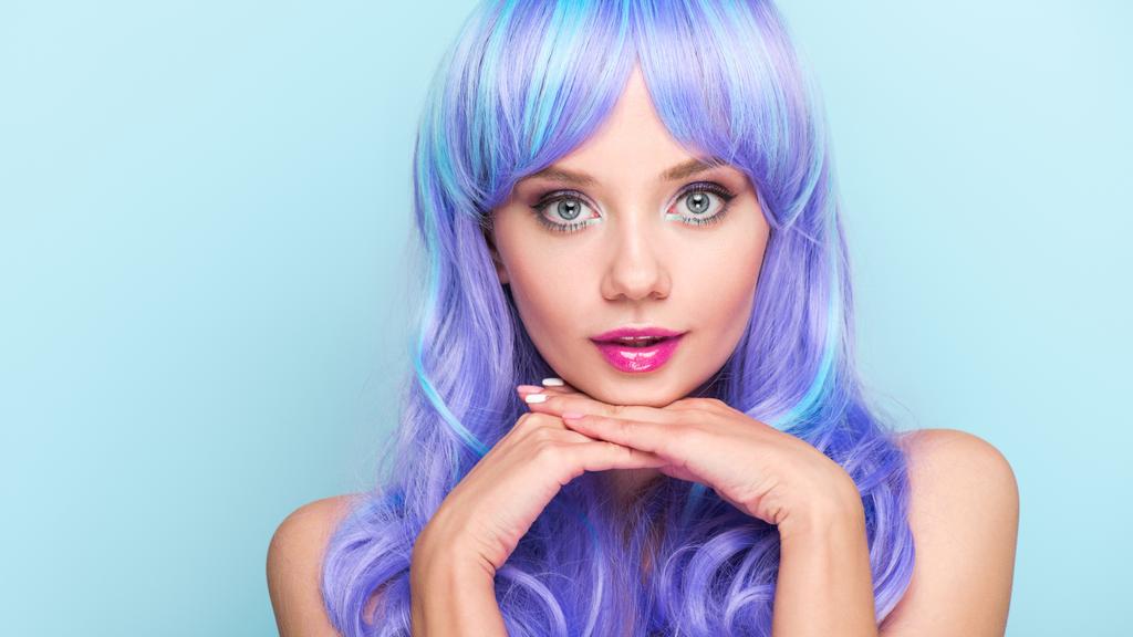 ελκυστική νεαρή γυναίκα με μπλε μαλλιά βλέπουν φωτογραφική μηχανή που απομονώνονται σε μπλε - Φωτογραφία, εικόνα