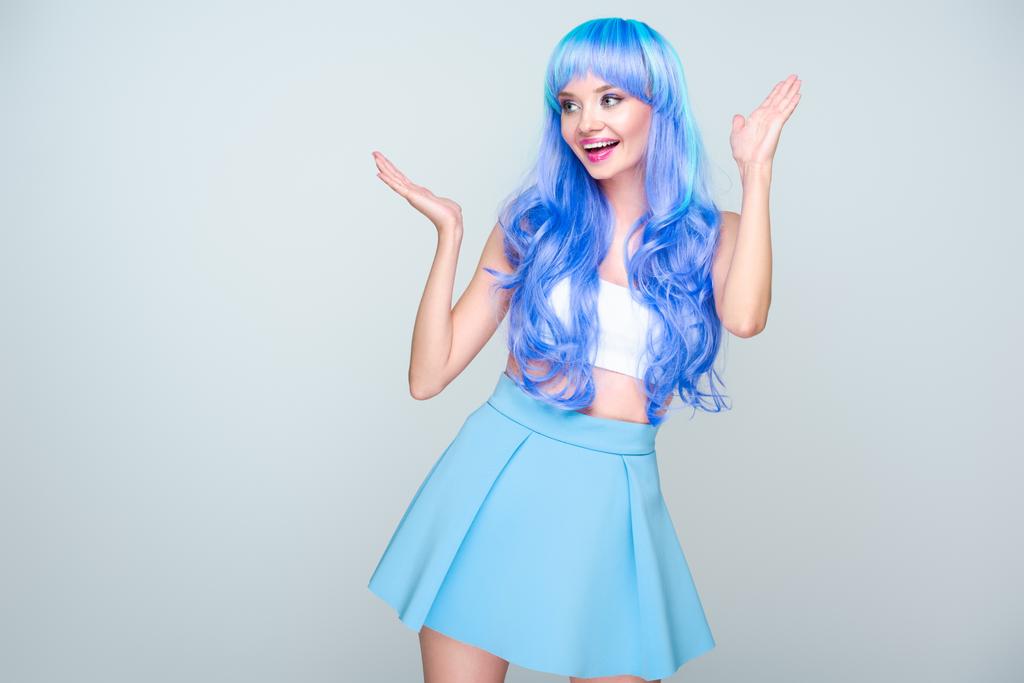 animado jovem mulher com cabelo azul brilhante e levantou as mãos isoladas no cinza
 - Foto, Imagem