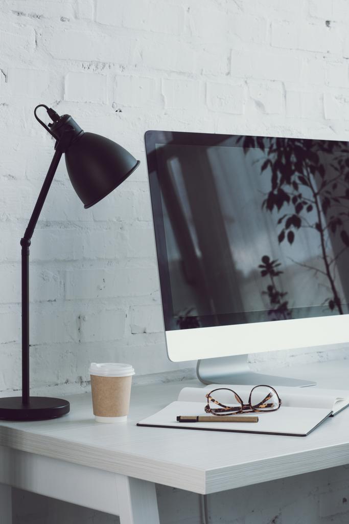 ordinateur et café dans une tasse en papier sur la table dans un espace de travail moderne
  - Photo, image