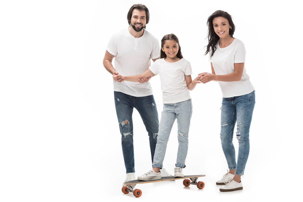 padres sonrientes ayudando a su hija a patinar en monopatín aislado en blanco
 - Foto, imagen