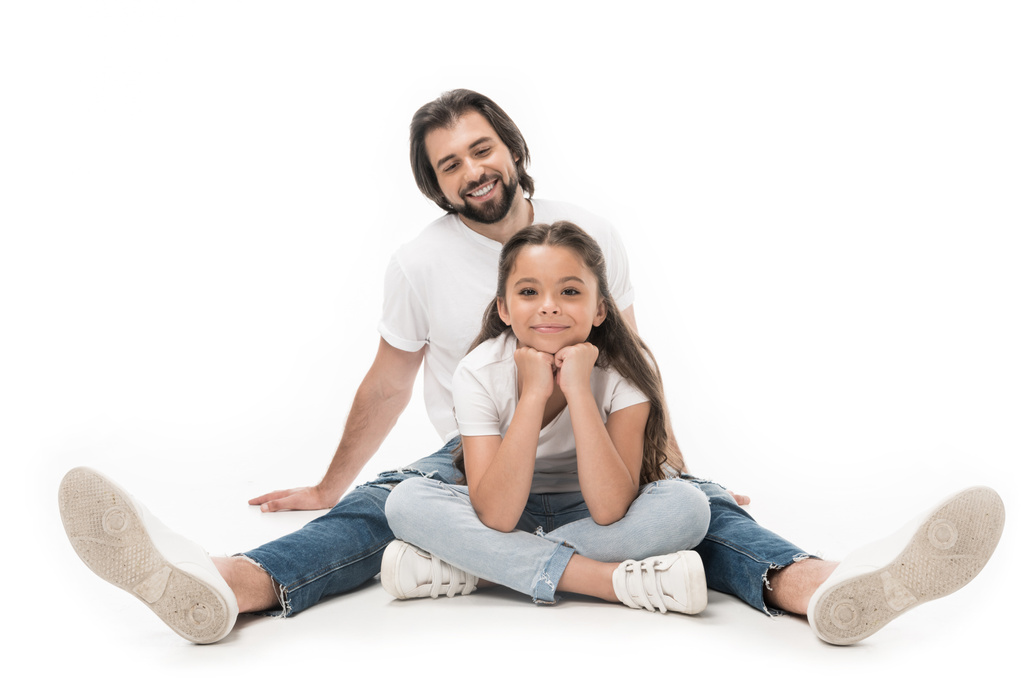 vrolijke vader en dochtertje in witte shirts en jeans geïsoleerd op wit - Foto, afbeelding