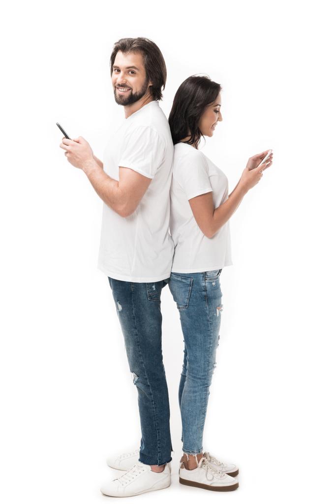 Çift üzerinde beyaz izole akıllı telefonlar ile yan görünüm - Fotoğraf, Görsel