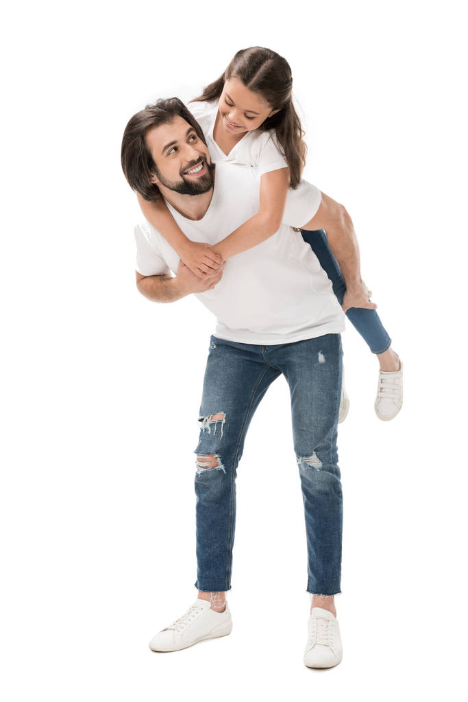 gülümseyen baba ve üzerinde beyaz izole küçük kız beyaz gömlek piggybacking içinde - Fotoğraf, Görsel