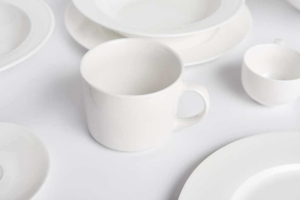 foco seletivo de várias placas, tigela e xícara na mesa branca
  - Foto, Imagem