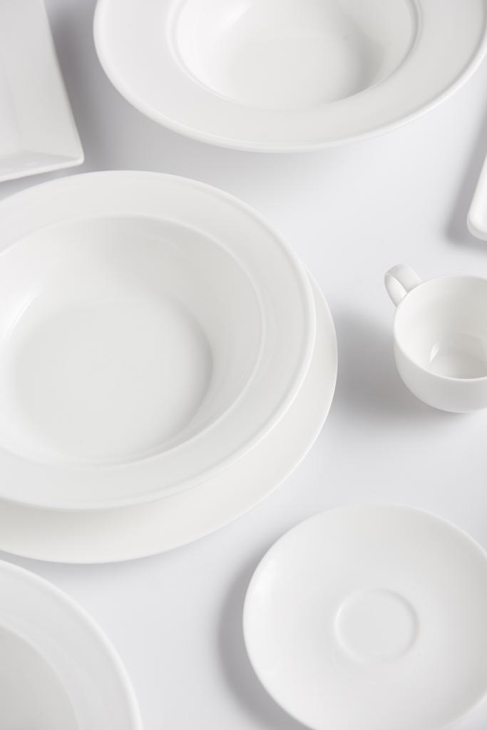 beyaz masa üzerinde çeşitli tabak ve bardak yüksek açılı görünüş - Fotoğraf, Görsel