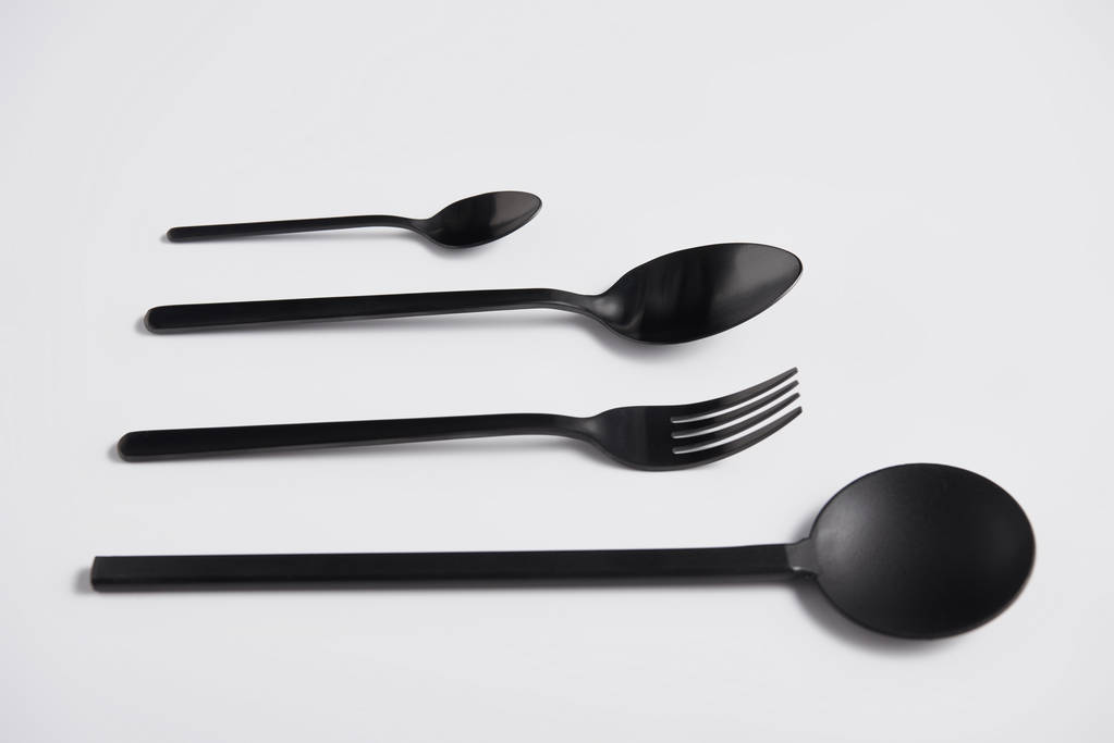 крупный план салатной ложки, вилки и ложки на белом столе, минималистская концепция
 - Фото, изображение