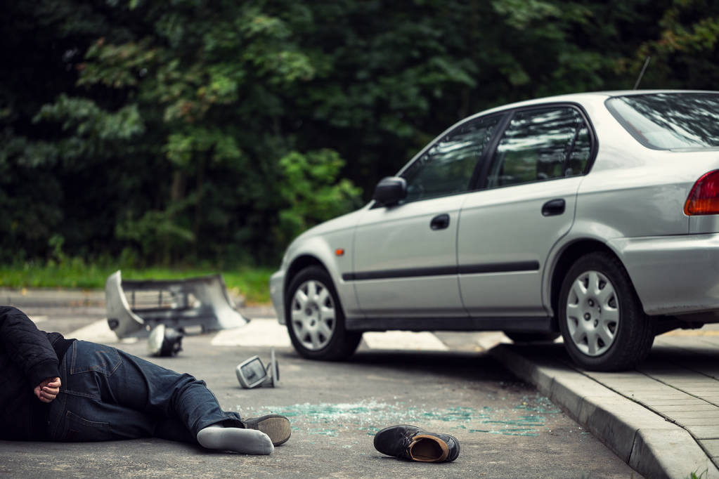 Opfer eines Verkehrsunfalls liegt neben Auto auf der Straße - Foto, Bild