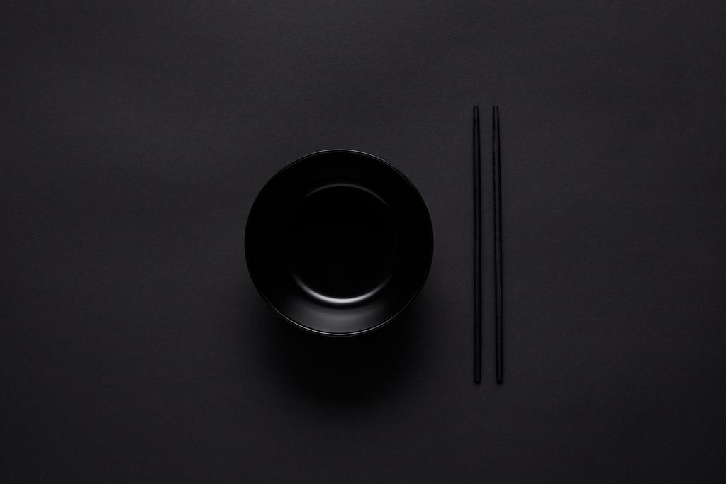 верхний вид черного и палочки для еды на черном столе, минималистическая концепция
 - Фото, изображение