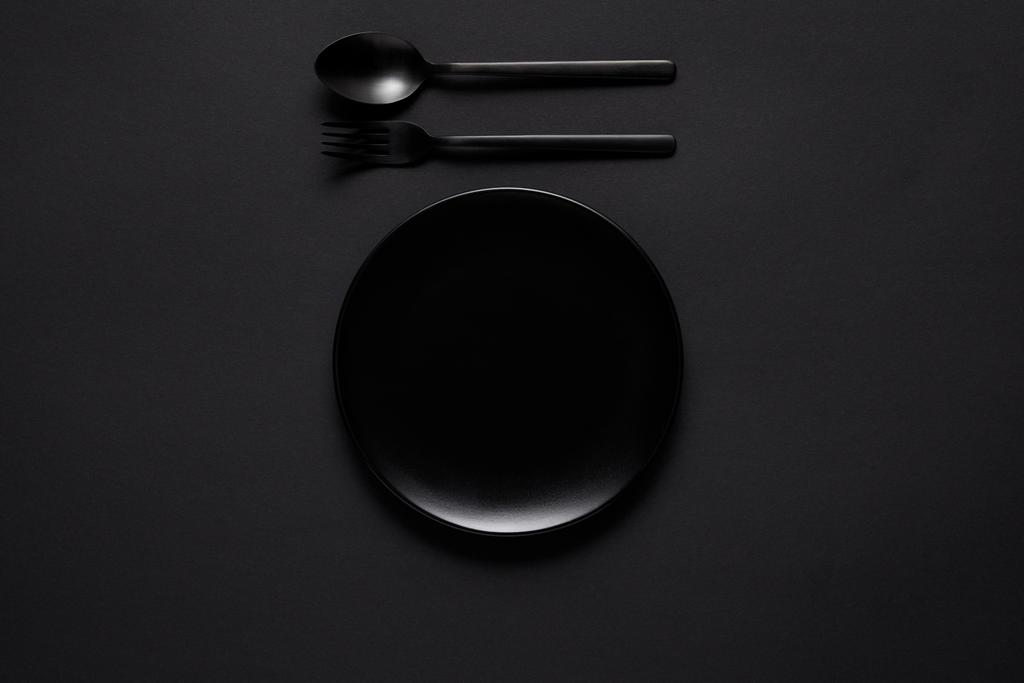felülnézet, fekete lemez, villát és kanalat a fekete tábla, minimalista koncepció - Fotó, kép