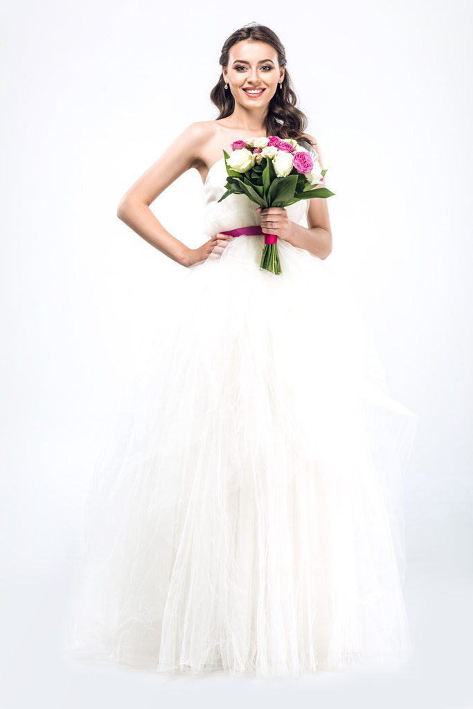 šťastná mladá nevěsta ve svatebních šatech s kyticí na bílém pozadí - Fotografie, Obrázek