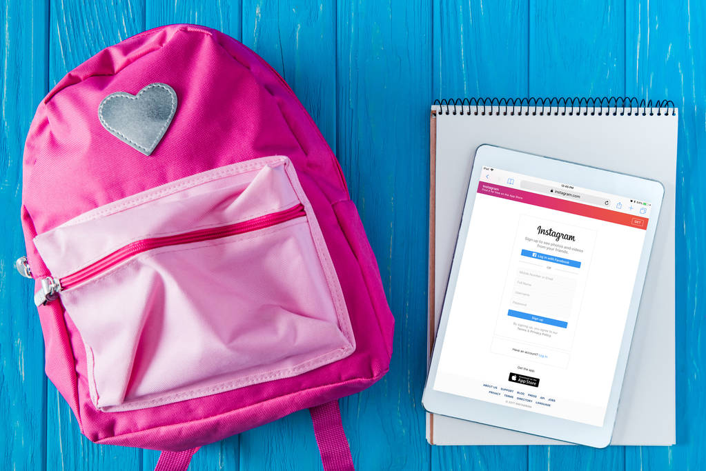 vista superior de la mochila rosa, libro de texto en blanco y tableta digital con el sitio web instagram en la pantalla
  - Foto, Imagen